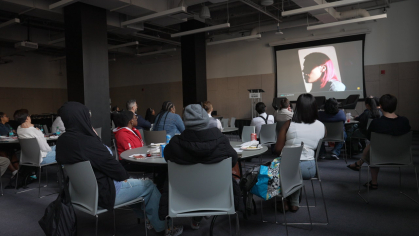 Event attendees contemplate the moving frames of A Woman on the Outside